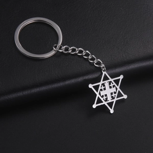 Detailed close-up of a silver stainless steel hexagram and cross keychain on black leather