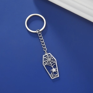 Gros plan du porte-clés cercueil gothique avec toile d'araignée sur fond bleu