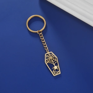 Détail macro du motif d'araignée dorée et de toile dans un porte-clés cercueil en acier inoxydable