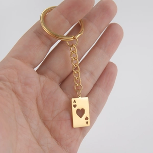 Golden stainless steel heart Ace playing card pendant keychain shown in hand for size
