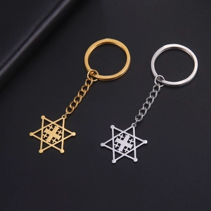 Detailed view of gold and silver hexagram Jerusalem cross keychains on black background