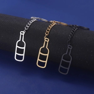 Macro detail of wine bottle keychains in silver gold and black finishes on blue background