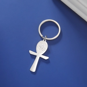 Detail of silver stainless steel Ankh pendant with lotus engraving on blue background
