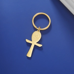 Detail of gold Ankh keychain with engraved lotus pattern on polished stainless steel