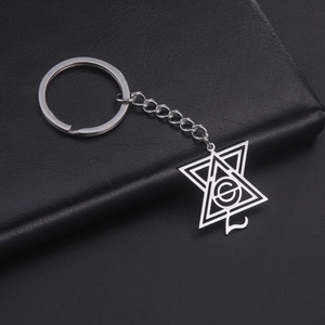 Vue macro du porte-clés pendentif triangle géométrique argenté avec lettre G sur cuir noir