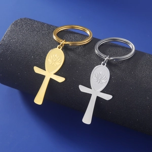 Polished gold and silver Ankh cross keychains with engraved lotus detail on black pedestal