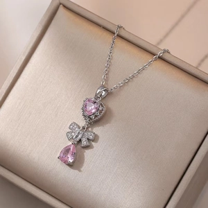 Three-layer pink gemstone necklace with heart, bow, and pear drop pendants in silver finish