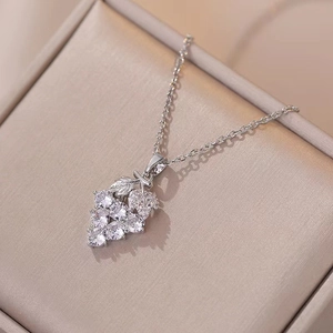 Silver-colored grape cluster necklace with sparkling zircon pendants on champagne silk background