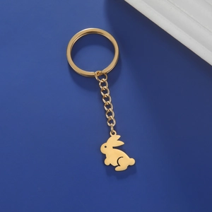 Detail of a golden rabbit keychain with a flat ring on a deep blue background