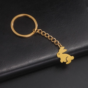 Macro detail of golden bunny pendant keychain with polished stainless steel surface