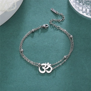 Macro detail of double-layer stainless steel anklet with Om charm and bead accents