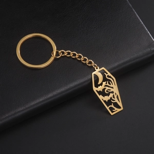 Detalle del colgante de ataúd en acero dorado con grabados de murciélagos y árboles