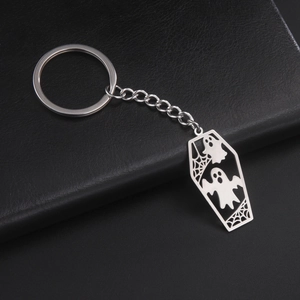 Detail of silver stainless steel coffin keychain with two ghosts and spider web design
