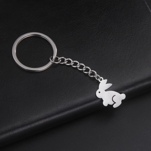 Detailed view of a polished silver stainless steel rabbit pendant on a black leather background