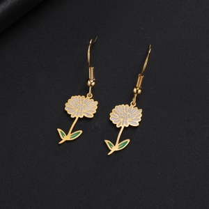 Détails macro de boucles d'oreilles fleurs en acier doré avec émail blanc sur noir