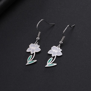 Détail des boucles d'oreilles fleurs blanches avec feuille verte en acier inoxydable argenté