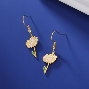 Vue détaillée des boucles d'oreilles marguerite avec pétales blancs et dorure fine