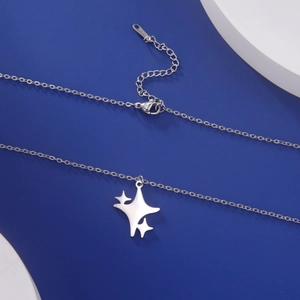 Gedetailleerde macro-opname van zilveren sterhanger ketting met S.Steel gravure en sluiting