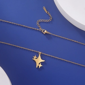 Detail van gouden sterhanger ketting met verstelbare ketting en sluiting op blauwe basis