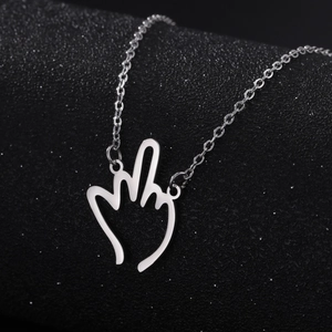 Detailaufnahme des silbernen hohlen Mittelfinger-Anhängers an einer feinen Edelstahlkette