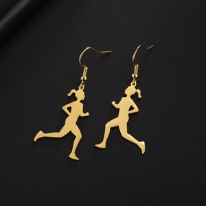 Macro detail of golden stainless steel earrings with running girl silhouette charms