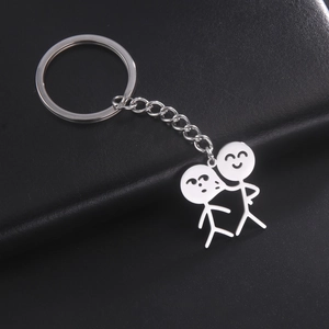 Détail d'un porte-clés en acier inoxydable argenté avec deux personnages de dessin animé