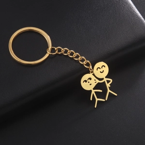 Porte-clés en acier inoxydable doré avec couple de bonshommes sur fond de cuir noir chic