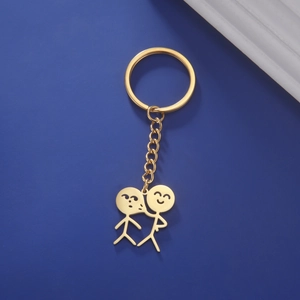Porte-clés doré avec pendentif couple s'embrassant sur fond bleu foncé profond