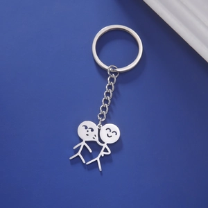 Gros plan d'un porte-clés en acier inoxydable argenté avec pendentif minimaliste de couple
