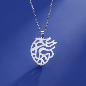 Surgical steel hollow anatomical heart pendant necklace with thin chain on blue background