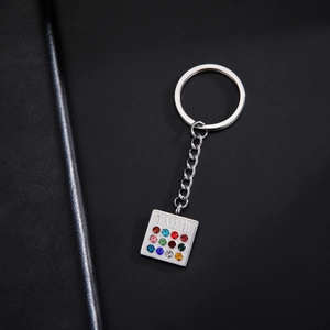 Macro shot of silver stainless steel keychain with Hoshen twelve stones on black leather