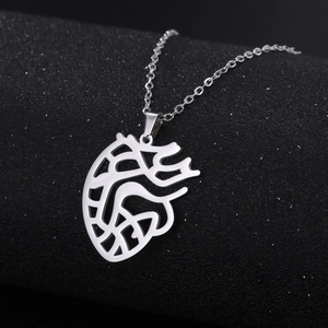 Macro detail of anatomical hollow heart pendant in polished silver stainless steel
