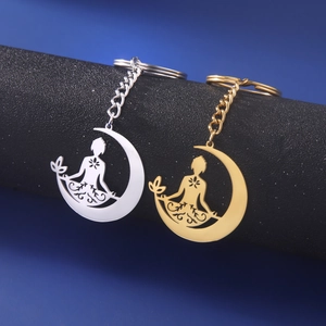 Vue détaillée des porte-clés croissant de lune et figurine de méditation en or et argent