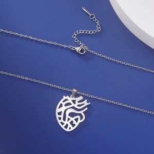 Macro shot of silver stainless steel anatomical heart pendant with S.STEEL engraved tag