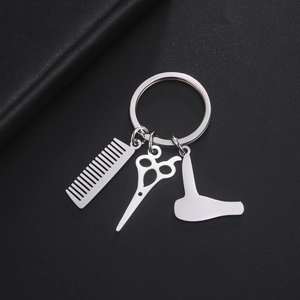 Close-up of hair stylist keychain charms including comb scissors and hair dryer