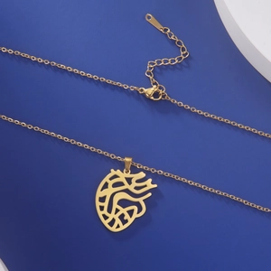Detailed macro view of gold anatomical heart pendant with delicate link chain and clasp