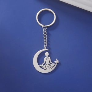 Détail du pendentif croissant de lune et lotus de méditation yoga sur porte-clés argenté