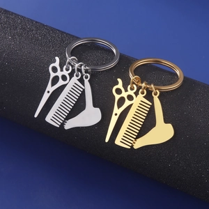 Detail view of silver and gold stainless steel hair stylist tool charms on keychains