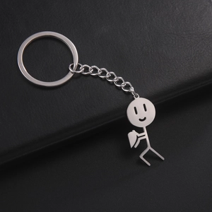 Detail van zilveren metalen sleutelhanger met speels luciferpoppetje die een hart vasthoudt