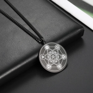 Détail du pendentif rond en acier inoxydable noir avec motif géométrique en étoile