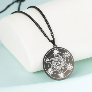 Détail du pendentif rond noir en acier inoxydable avec gravure géométrique du cube de Métatron