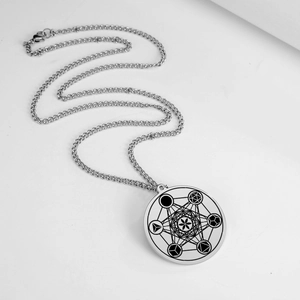 Vue détaillée du collier pendentif rond argenté avec motif géométrique sacré gravé