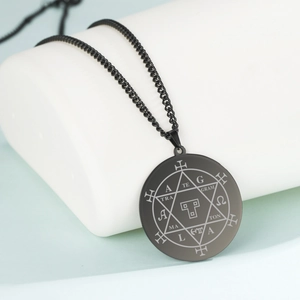 Nahaufnahme des schwarzen Edelstahlanhängers mit Hexagramm und Symbolen auf weißem Stand