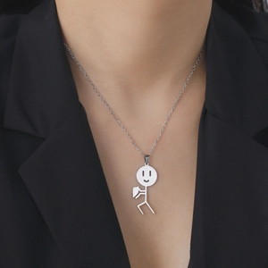 Dettaglio della collana con ciondolo a cuore e omino in acciaio inossidabile argento
