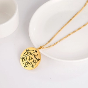 Detailansicht der goldenen Hexagramm-Kette mit mystischen Runen auf weißem Tablett
