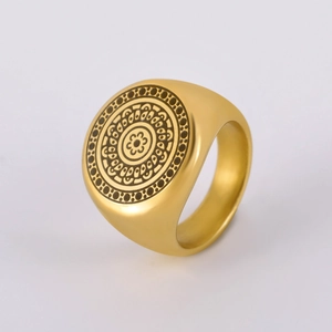 Macro detail of gold stainless steel ring with laser-etched mandala geometric pattern