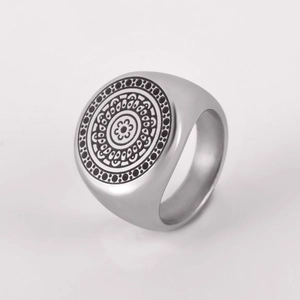Macro shot of silver stainless steel ring with intricate laser engraved totem patterns