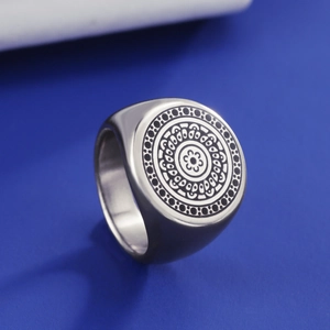Macro shot of silver stainless steel signet ring with engraved vintage mandala pattern