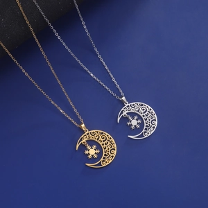 Detailed close-up of crescent moon and snowflake pendant on polished stainless steel chain