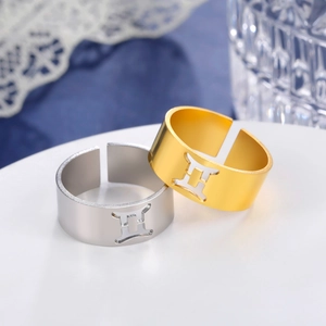 Macro shot of gold and silver stainless steel zodiac open rings with Gemini symbol.